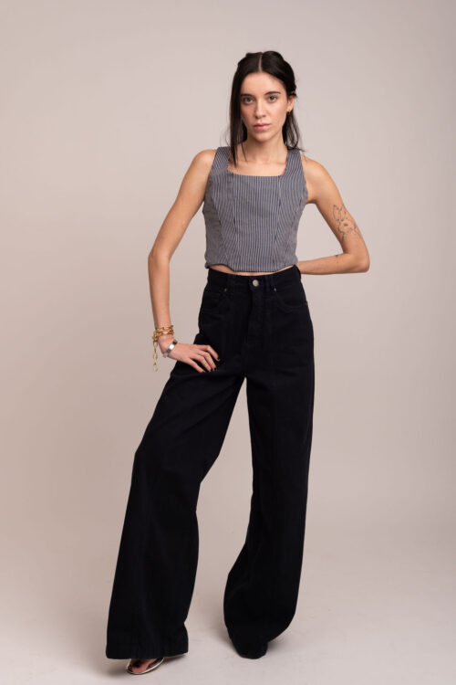 Modelo posa de corpo inteiro usando corset de alfaiataria estruturado e calças largas pretas sobre fundo branco neutro. Imagem que destaca o design e a modelagem do Corset Jade.